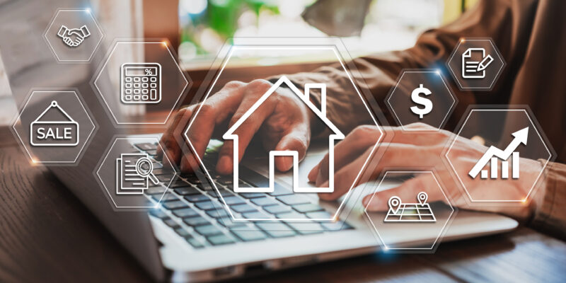 Person typing on a laptop with real estate related icons floating above their hands.